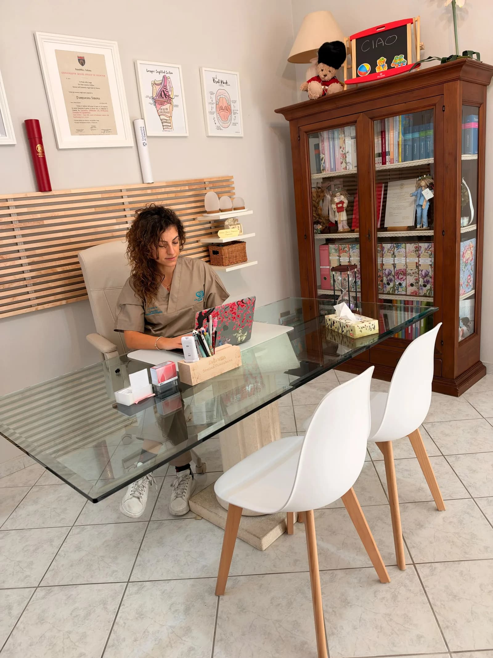 Simona Pamparana alla scrivania di vetro dello studio mentre scrive al computer, dove prende forma il piano di lavoro